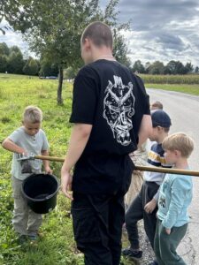 Lehrer mit Kindern bei der Apfelernte.